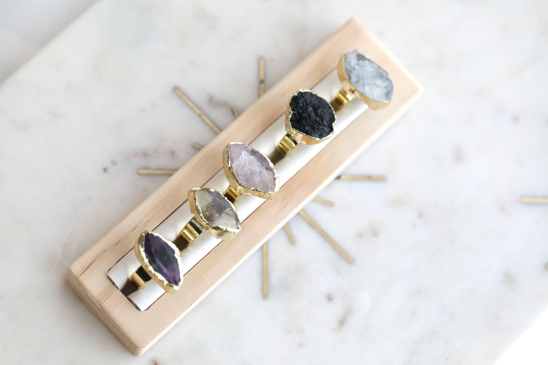 Close-up of Black Tourmaline, Fluorite, Lemon Quartz, Amethyst, and Rose Quartz Crystal Rings by Mrs V